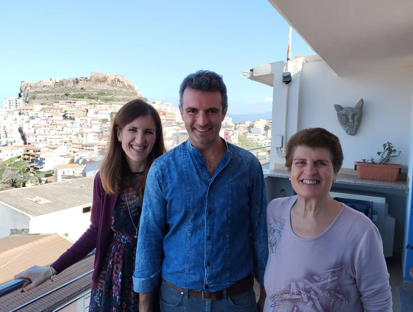 Letizia Pileri con la famiglia sul terrazzo, con il castello di Castelsardo sullo sfondo