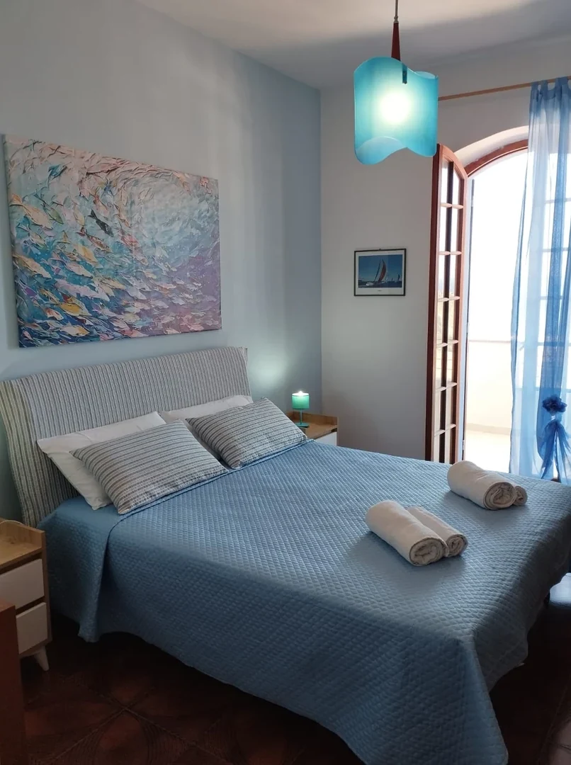 La camera matrimoniale con il copriletto blu e il quadro dei pesci