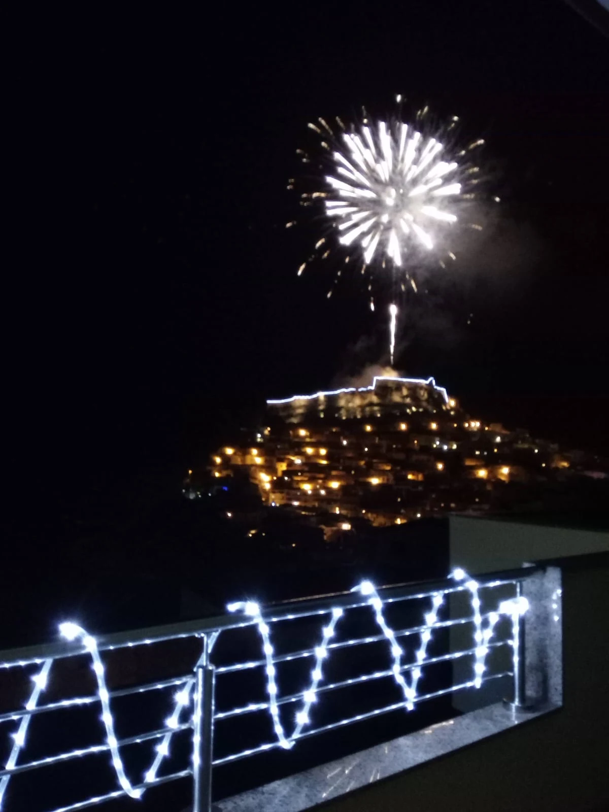 I fuochi d'artificio sopra il borgo illuminato, visti dal terrazzo