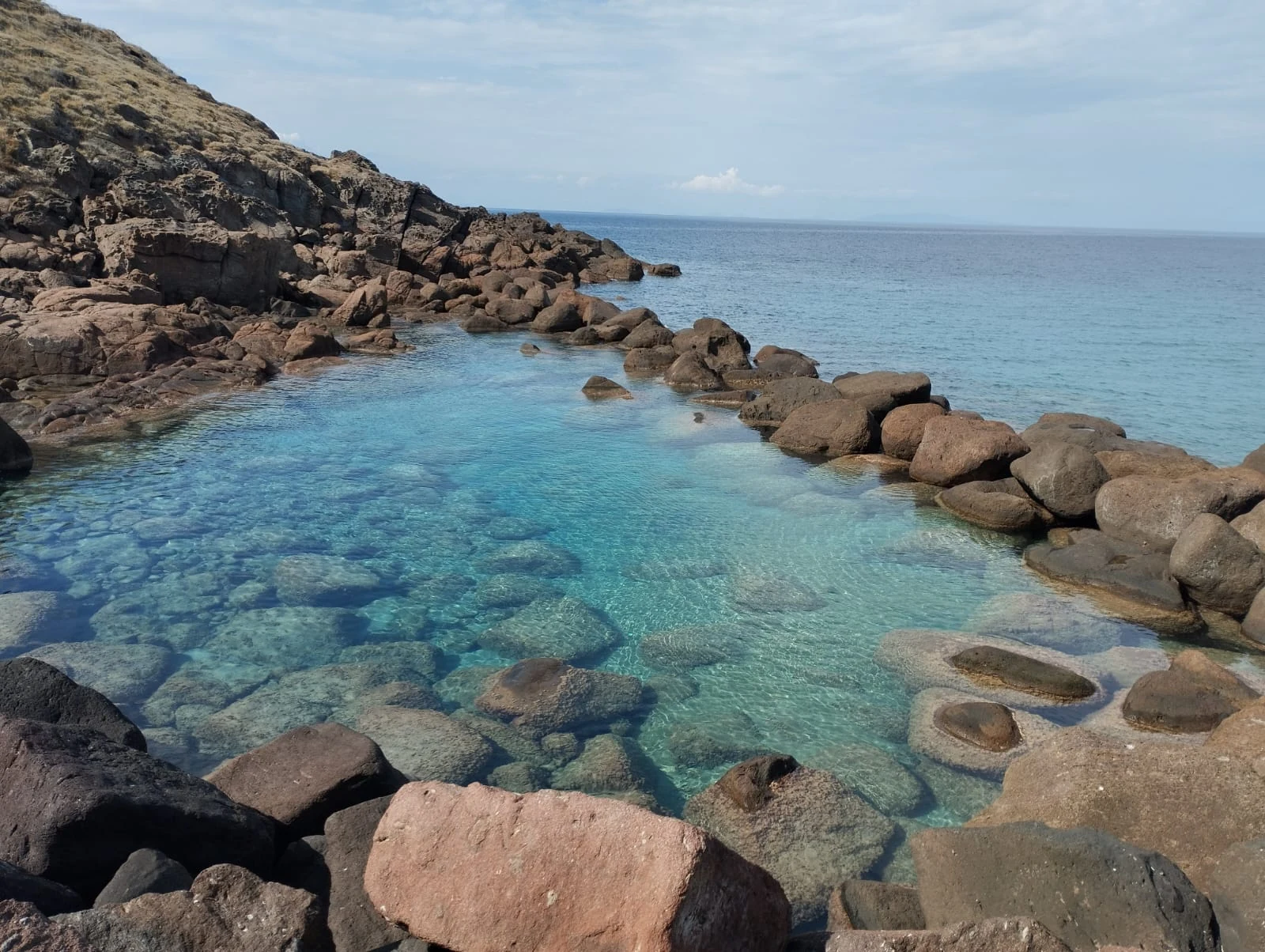 Una piscina naturale fra gli scogli, con l'acqua trasparente