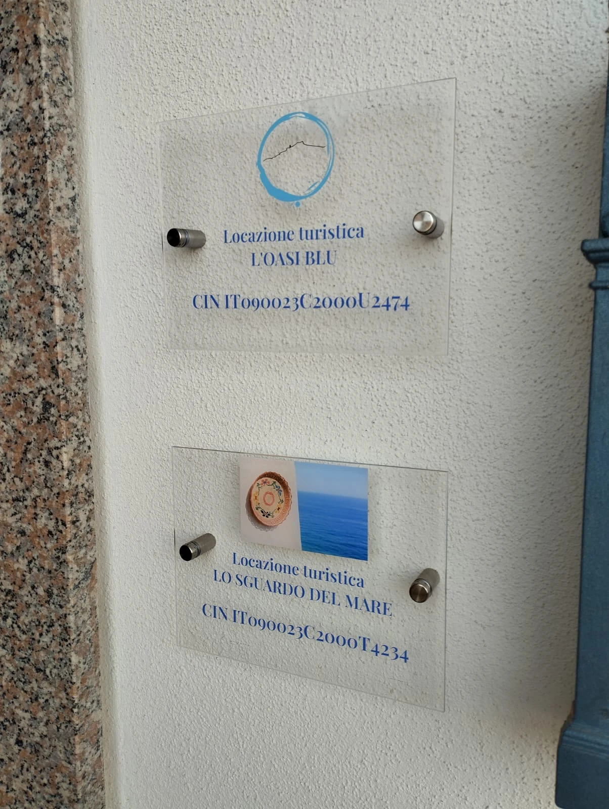 Le targhe di Oasi Blu e Lo sguardo del mare all'ingresso della palazzina