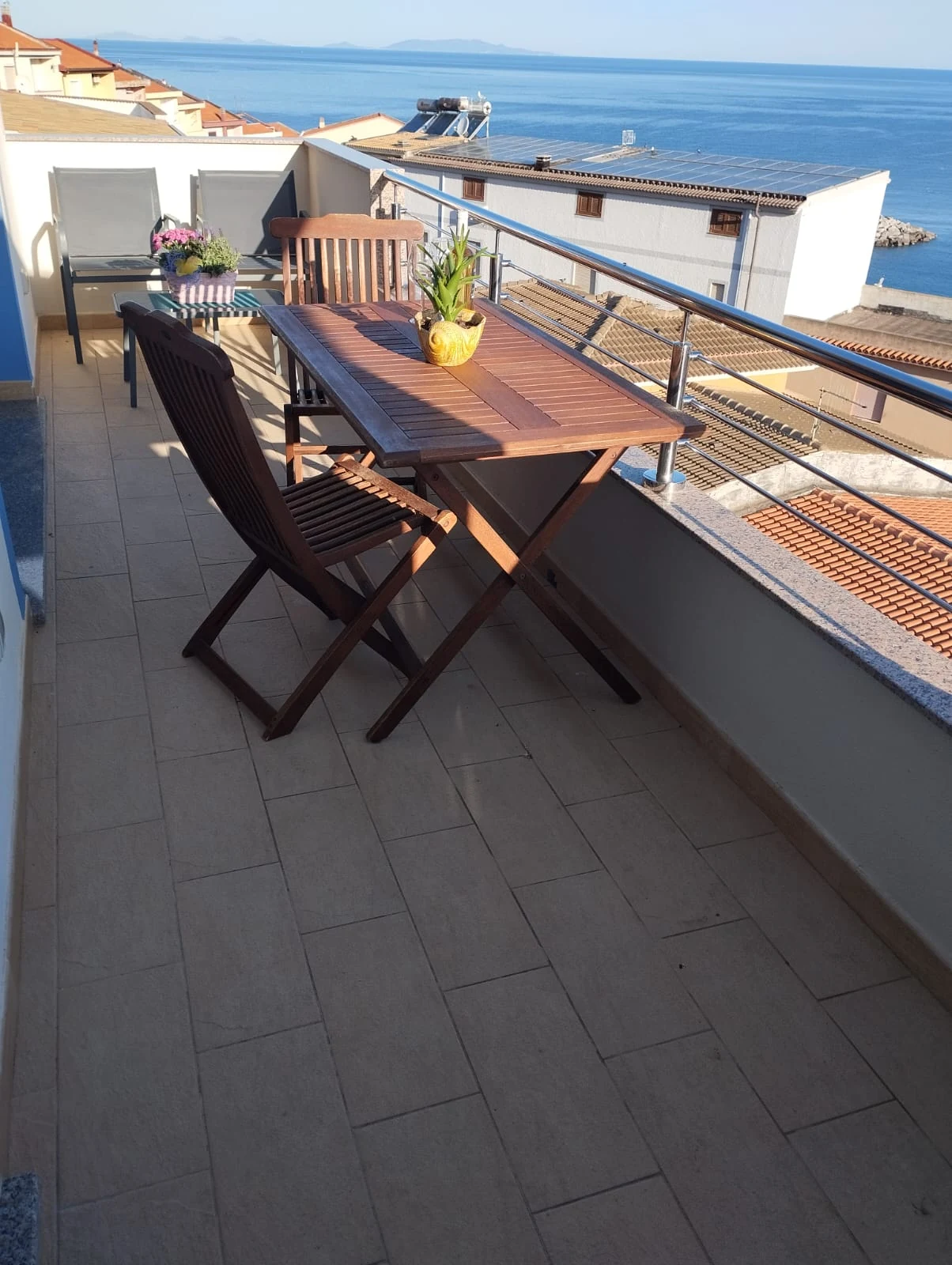 Il terrazzo con il tavolo in legno e la vista sul mare
